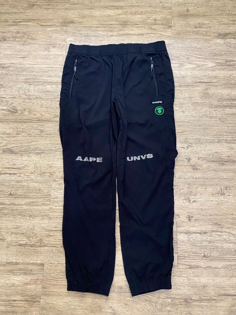 BAPE AP-201209 Black Track Pants (Category: Joggers) located in Cebu City. Submitted by francloset_1 (Listing ID 1444537709, Image 1). Description: - Authentic BAPE track pants - Features iconic ape head logo and "BAPE" text graphics - Comfortable elastic waistband with drawstring - Convenient zippered side pockets - Includes a back pocket detail - Ideal for casual outings or sports activities -Dimes W16 L 37.5 Ins 14 T12 H 6.