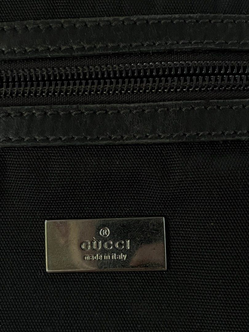Gucci Black Nylon Messenger Bag (Category: Luxury Bags & Wallets) located in Manila. Submitted by jj_thrift (Listing ID 1444616145, Image 2). Description: - Authentic Gucci messenger bag - Made in Italy - Durable nylon with leather trim - Adjustable strap for comfortable wear - Main zip compartment - Front flap pocket with buckle closure - Metal Gucci logo plate on front - Gucci logo on zipper pull - Minor signs of wear on hardware.