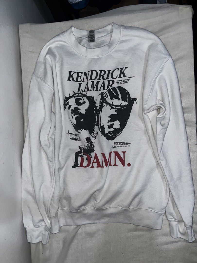 Kendrick Lamar DAMN. Crewneck Sweatshirt (Category: Hoodies) located in Makati City. Submitted by gabrayco (Listing ID 1444618577, Image 1). Description: - White crewneck sweatshirt - Features Kendrick Lamar's DAMN. album art on the front - Back displays the DAMN. album tracklist and credits - Gildan Heavy Blend tag - Ideal for any Kendrick Lamar fan - dimes: Width(pit to pit) 21.5 inches length 26 inches very good condition.