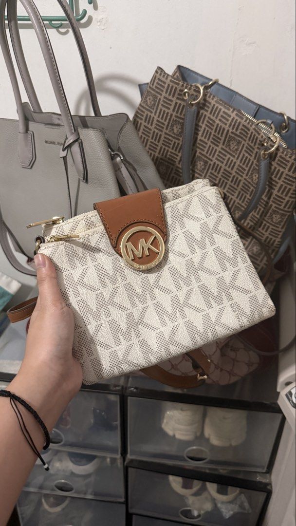 Michael Kors MK Signature Monogram Wallet Pouch (Category: Luxury Bags & Wallets) located in Manila. Submitted by backupaccount2 (Listing ID 1444631784, Image 1). Description: - Authentic Michael Kors monogram wallet pouch - Color: White and brown - Multiple card slots - Zippered compartments for secure storage - Elegant gold hardware details - Detachable wrist strap for convenience - Ideal for organizing your daily essentials.