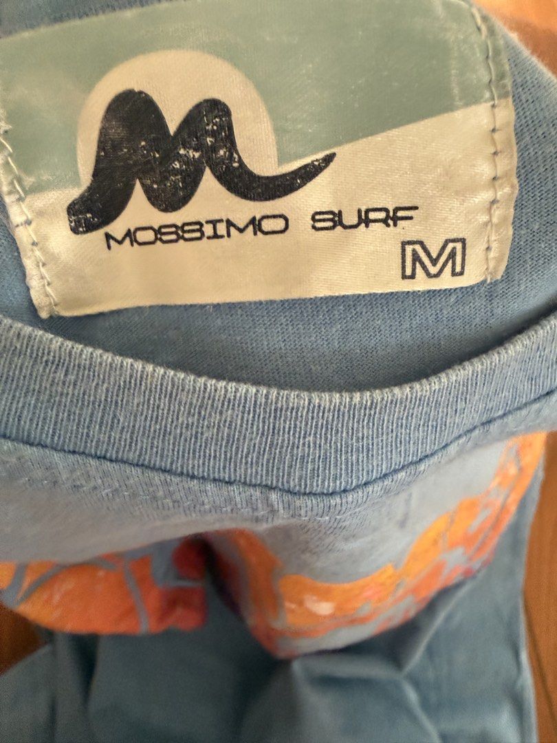 Mossimo Surf Blue T-shirt Size M (Category: Tshirts & Polo Shirts ) located in Bulacan. Submitted by emjay_17 (Listing ID 1444578787, Image 2). Description: - Brand: Mossimo Surf - Color: Light Blue - Size: Medium (M) - Design: Front graphic print featuring a peace sign and heart - Style: Casual wear.