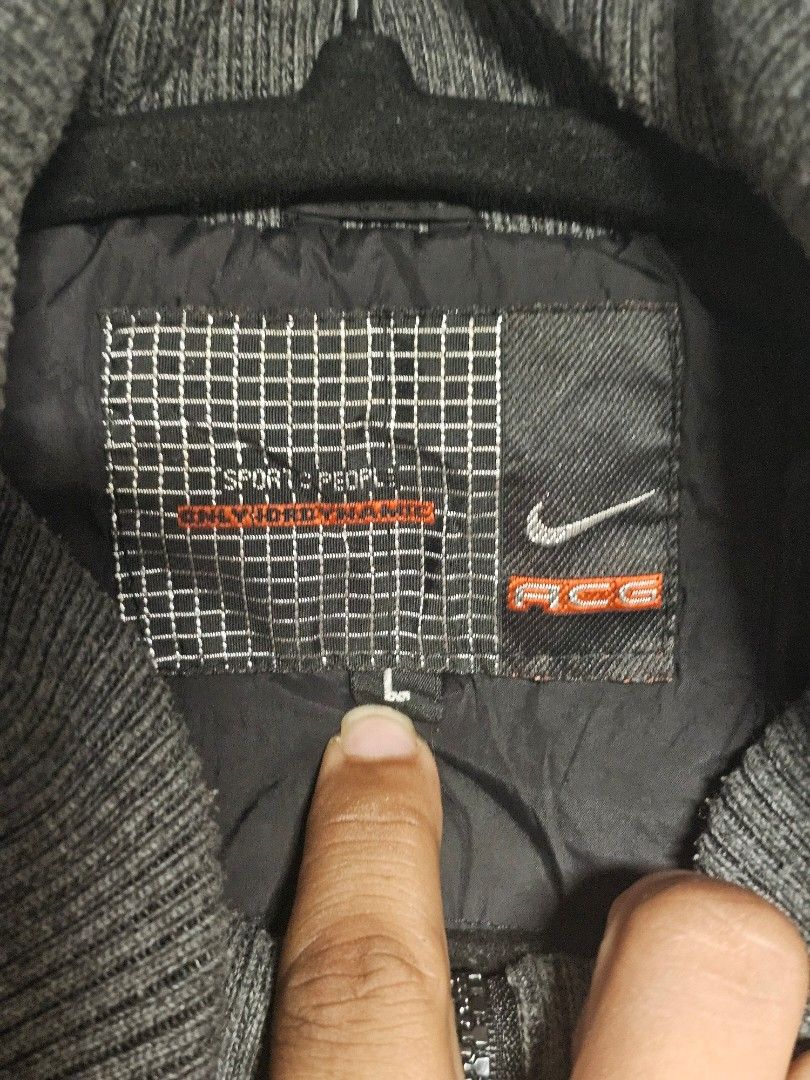 Nike ACG Black Puffer Jacket with Hood (Category: Coats, Jackets and Outerwear) located in Manila. Submitted by thrift_archive (Listing ID 1444633807, Image 3). Description: - Black Nike jacket - Size L - Hooded design - Ribbed cuffs and collar - Large Nike graphic on the back - Multiple front pockets - Ideal for cooler weather dimes 23wx27L.