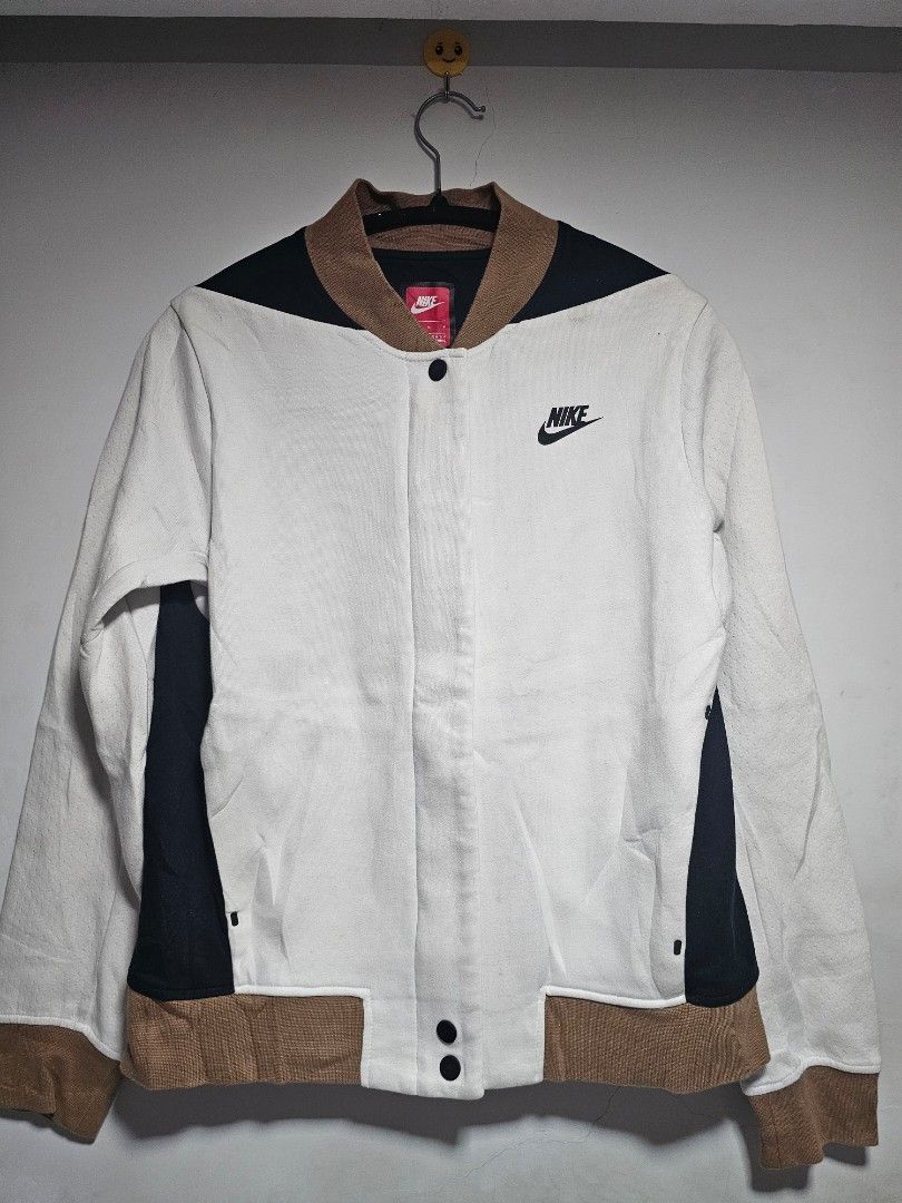 Nike tech fleece Bomber Jacket White Black Brown (Category: Coats, Jackets and Outerwear) located in Manila. Submitted by thrift_archive (Listing ID 1444645667, Image 1). Description: - Classic Nike Bomber Jacket - Colorway: White, Black, and Brown - Button closure for a secure fit - Iconic Nike logo embroidered on the chest - Ribbed collar, cuffs, and hem for comfort and style - Ideal for everyday casual wear - Please check photos for condition 