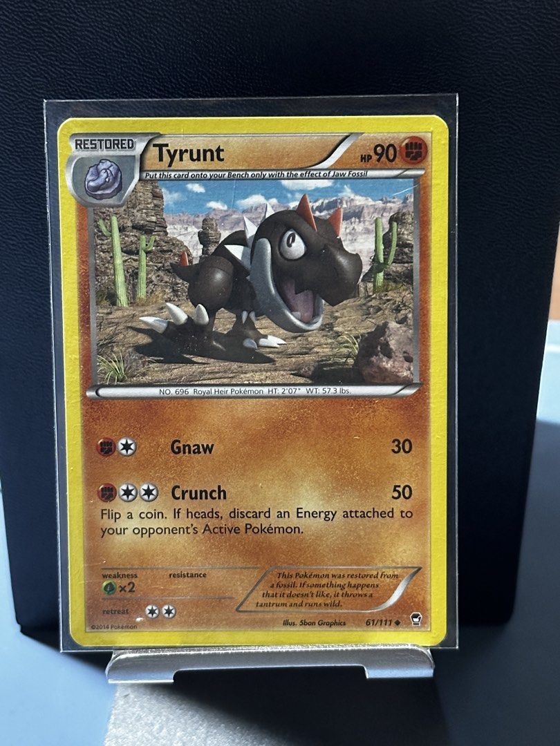 Pokemon Card - Tyrunt 61/111 (Category: Raw Singles) located in Cavite. Submitted by debbieafrica (Listing ID 1444527745, Image 1). Description: - Tyrunt Pokemon Card (61/111) - Restored from a fossil - 90 HP - Attack 1: Gnaw (30 damage) - Attack 2: Crunch (50 damage) - Flip a coin to discard an energy card - Ideal for collectors!.