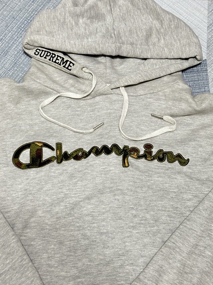 Supreme Champion Grey Hoodie (Category: Hoodies) located in Cavite. Submitted by remcadzzz (Listing ID 1444649726, Image 2). Description: - Grey Champion hoodie with Supreme detail on hood. - Unique camo print on the Champion logo. - Size: Large. - Perfect for everyday casual wear. - 21x24.