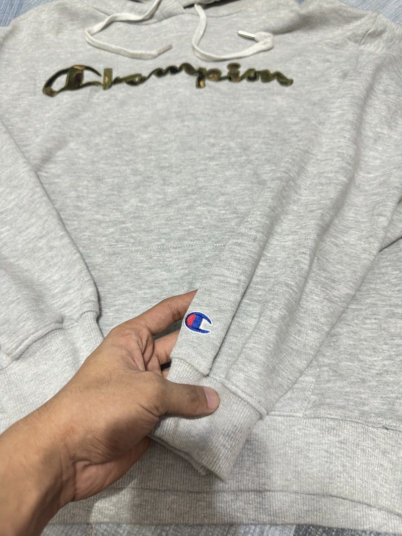 Supreme Champion Grey Hoodie (Category: Hoodies) located in Cavite. Submitted by remcadzzz (Listing ID 1444649726, Image 3). Description: - Grey Champion hoodie with Supreme detail on hood. - Unique camo print on the Champion logo. - Size: Large. - Perfect for everyday casual wear. - 21x24.