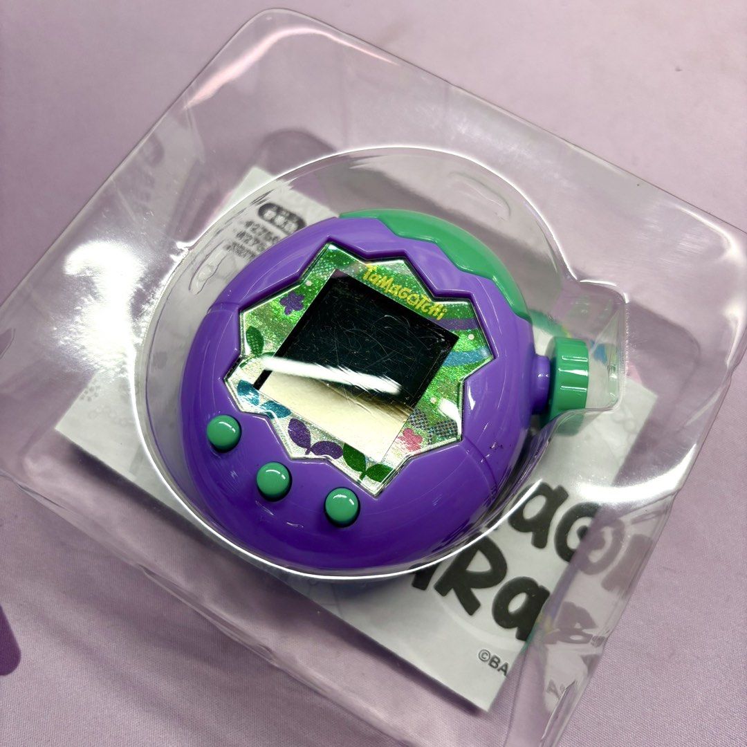 Tamagotchi Paradise Pink Land Virtual Pet (Category: Interactive Toys) located in Manila. Submitted by mcamillevo (Listing ID 1444573503, Image 2). Description: - Tamagotchi Paradise Pink Land virtual pet - Color: Purple with green accents - Features a cute character on screen - Comes in its original box - Swapped the shells SF to be shouldered by buyer, based in Makati.