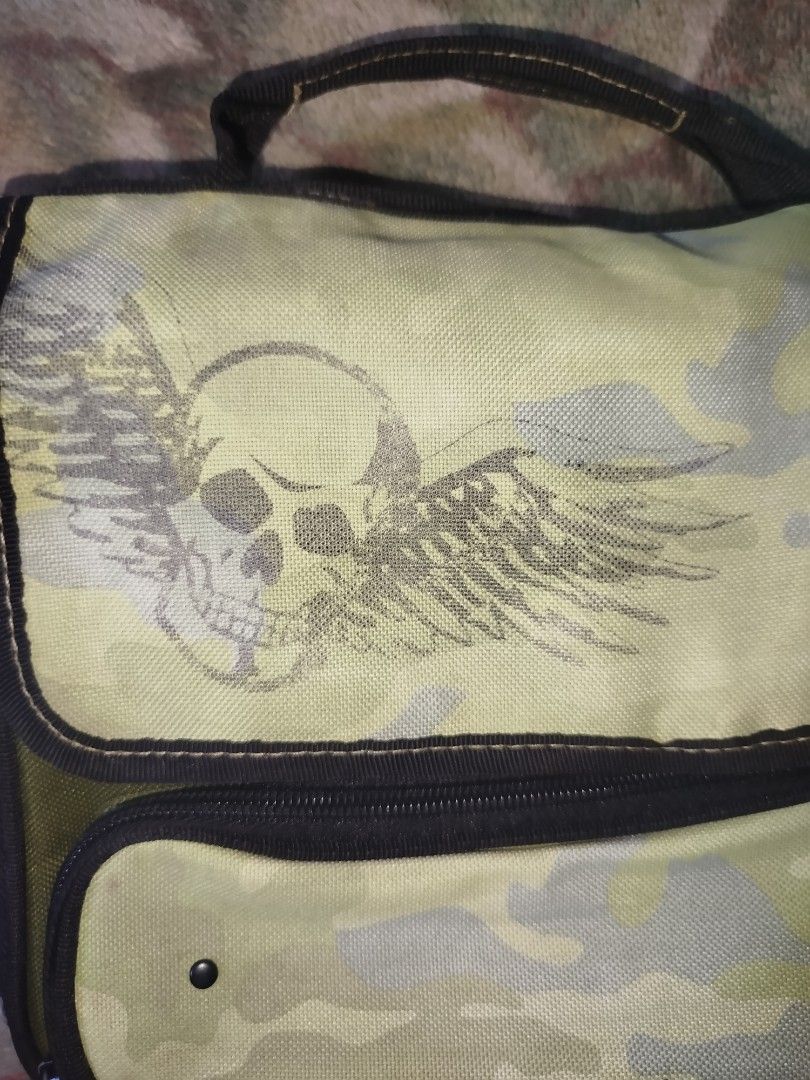 Thermos Camo Skull Lunch Bag y2k (Category: Belt bags, Clutches and Pouches) located in Quezon City. Submitted by pezx0 (Listing ID 1444550709, Image 3). Description: - 400+sf - no issue - tylish camouflage thermos lunch bag - Features a cool skull and wings graphic on the front - Inside lining with repeating skull pattern - Secure zipper closure - Convenient top handle for easy carrying - Ideal for packing lunches and keeping food fresh.