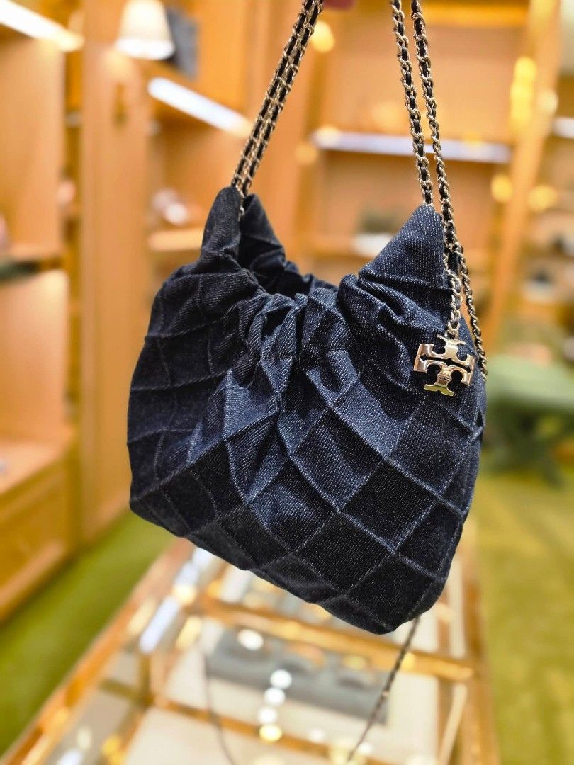 Tory Burch Freming Mini Hobo Bag (Category: Luxury Bags & Wallets) located in Manila. Submitted by mylittlewardrobe88 (Listing ID 1444658675, Image 2). Description: - Stylish denim Tory Burch bag - Unique ruched and quilted design - Elegant gold chain strap - Signature Tory Burch logo charm - Versatile for casual or dressed-up looks - Spacious enough for daily essentials.