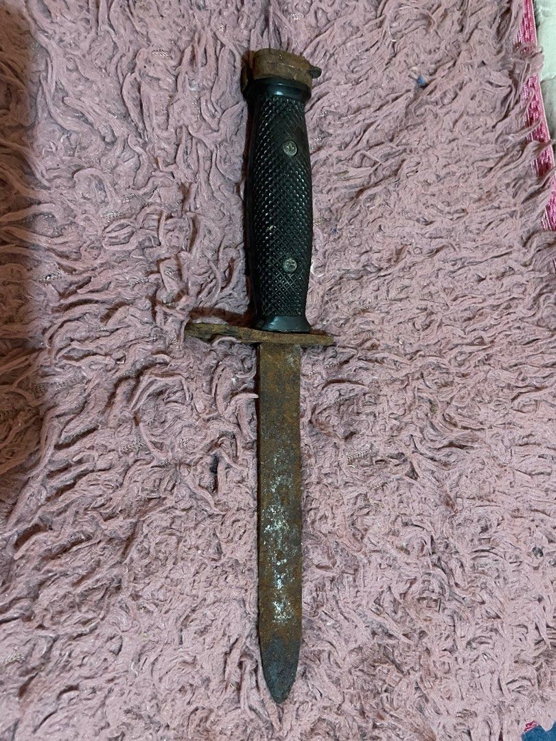 Vintage Bayonet Knife with Black Handle (Category: Vintage Collectibles) located in Dipolog. Submitted by simonpeterdenila (Listing ID 1444605634, Image 1). Description: - Vintage bayonet knife - Shows significant rust and wear - Black textured handle with scuffs - Metal guard and pommel - Blade is dull and pitted - Ideal for display or restoration projects - Ring on guard is intact.