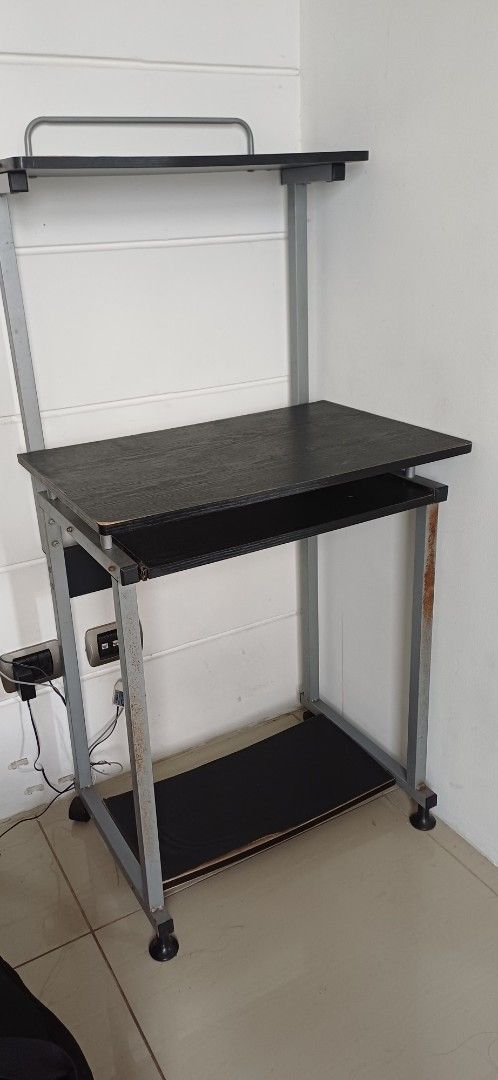 Computer table (Category: Shelves, Cabinets & Racks) located in Antipolo. Submitted by cone0812 (Listing ID 1444729269, Image 3). Description: - Two-tier rolling storage shelf - Black laminate surfaces - Sturdy metal frame - Convenient handle for easy moving - Wheels for effortless maneuverability - Some rust spots on metal frame (adds character!) - Ideal for organizing any space.