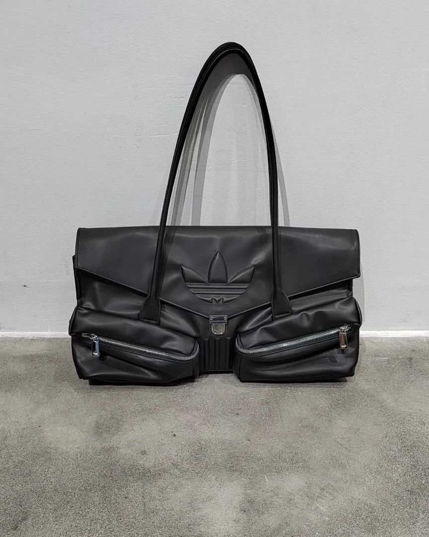 Adidas Black Leather Shoulder Bag with Silver Hardware (Category: Shoulder Bags) located in Quezon City. Submitted by dawn_18 (Listing ID 1444807598, Image 1). Description: - Adidas black leather shoulder bag - Iconic trefoil logo embossed on front - Two large zippered pockets on the front - Central clasp closure - Long straps for shoulder wear - Spacious design, perfect for everyday use.