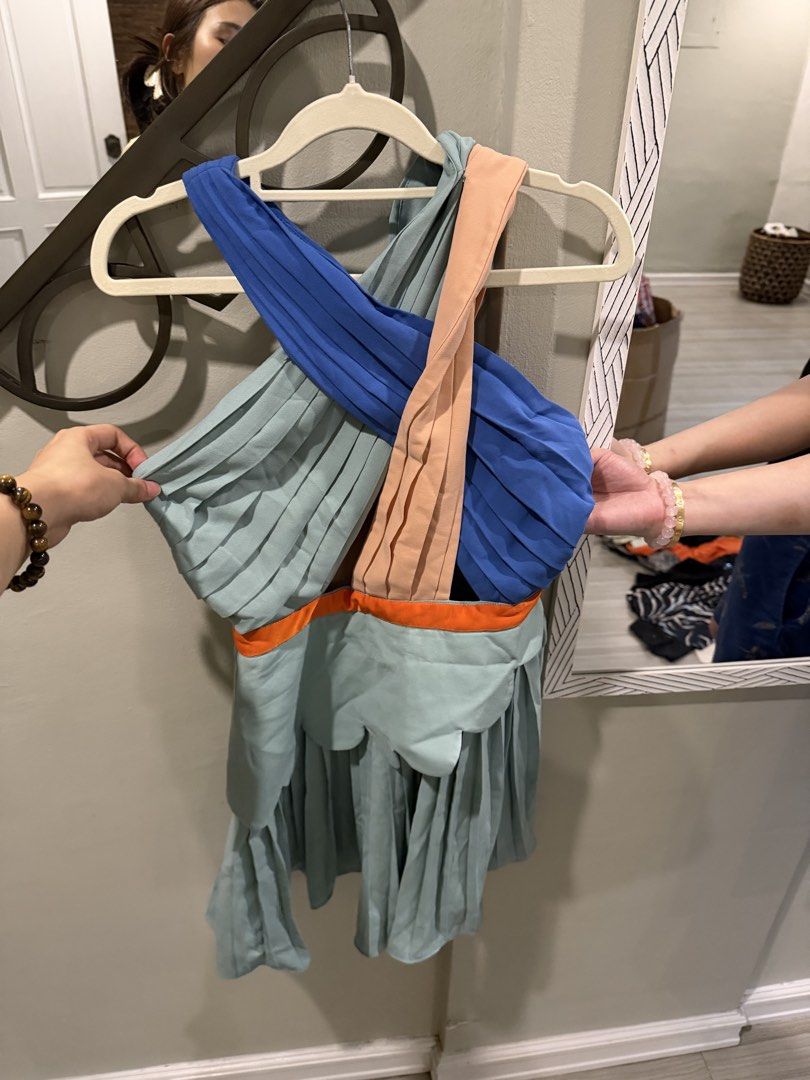 Asymmetrical Pleated One-Shoulder Dress (Category: Dresses) located in Makati City. Submitted by sug_ilab09 (Listing ID 1444840362, Image 2). Description: - Unique asymmetrical design - Pleated fabric - Mix of blue, light blue, and peach colors - Orange trim detail - One-shoulder style with criss-cross straps - Fun and flirty vibe - Ideal for parties or a night out.