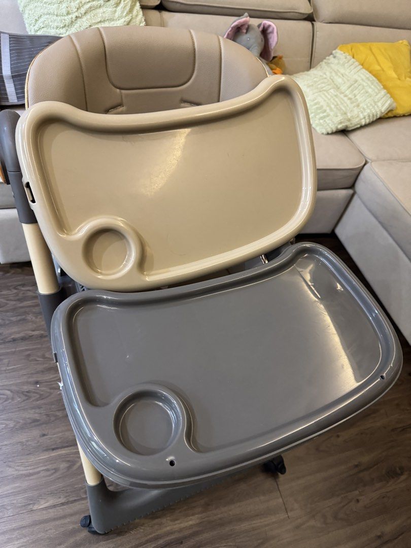 Baby High Chair with Tray and Footrest (Category: Baby High Chairs) located in Singapore. Submitted by hahask (Listing ID 1444856149, Image 2). Description: - Adjustable baby high chair - Removable tray - Footrest included - Safety harness for secure seating - Wheels for easy movement around the house - Neutral beige seat and tray - Light wood tone frame with grey accents - Ideal for meal times.