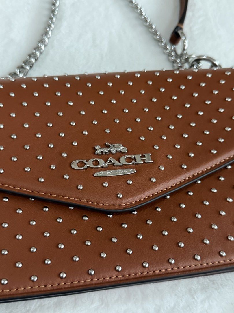 Coach Rivet Studded Crossbody Bag Pecan (Category: Cross-body Bags) located in Cebu City. Submitted by thestylemd (Listing ID 1444761709, Image 3). Description: - Coach crossbody bag - Color: Pecan - All-over silver stud detailing - Silver chain strap - Envelope flap closure - Comes with original tags - Ideal for nights out or adding an edgy touch to everyday wear.