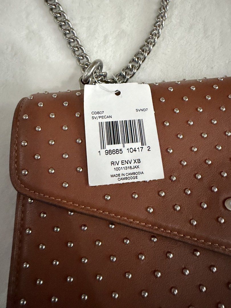 Coach Rivet Studded Crossbody Bag Pecan (Category: Cross-body Bags) located in Cebu City. Submitted by thestylemd (Listing ID 1444761709, Image 2). Description: - Coach crossbody bag - Color: Pecan - All-over silver stud detailing - Silver chain strap - Envelope flap closure - Comes with original tags - Ideal for nights out or adding an edgy touch to everyday wear.