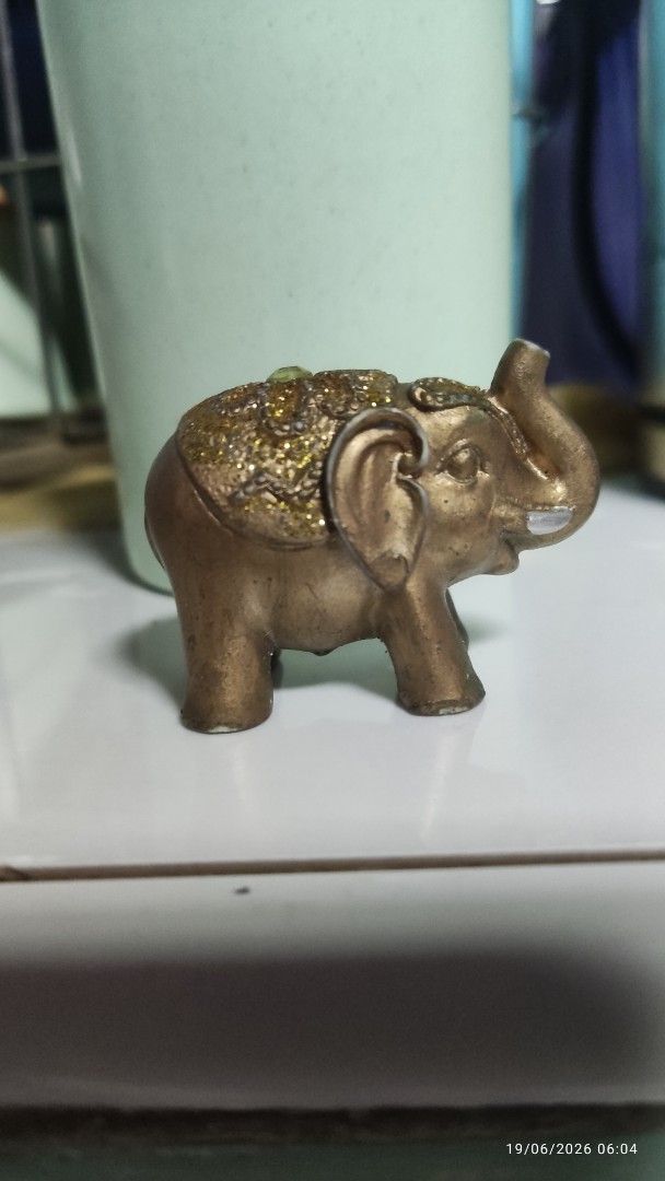 Decorative Bronze Elephant Figurine with Glitter Accent (Category: Other Home Decor) located in Manila. Submitted by ruane_raleigh12 (Listing ID 1444684200, Image 1). Description: - Adorable little elephant figurine - Bronze color with sparkling glitter details on back and head - Compact and small size, ideal for display - Perfect for shelves, desks, or as a decorative accent - A charming addition for collectors or as a small gift mabigat siya.