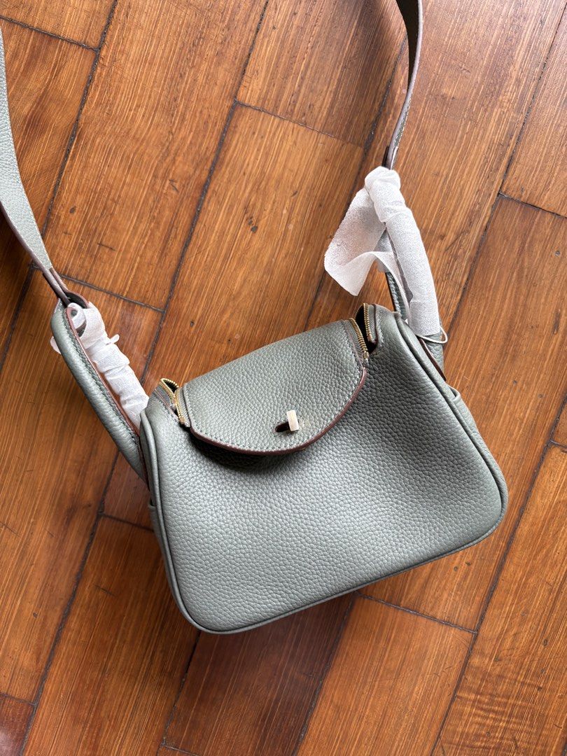 Designer Style Leather Handbag (Category: Luxury Bags & Wallets) located in Pasig City. Submitted by mvsdb (Listing ID 1444695627, Image 2). Description: - Grey pebbled leather handbag - Top handles and detachable shoulder strap - Elegant gold hardware details - Secure zip closure for the main compartment - Convenient small flap pocket on the front - Protective plastic still on some hardware - Ideal for everyday use.