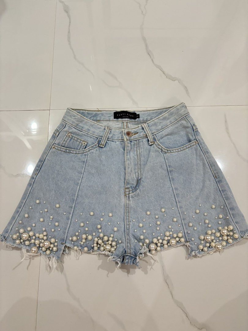 FANYI PURE light-wash denim shorts (Category: Skirts) located in San Fernando. Submitted by annecurates (Listing ID 1444761650, Image 2). Description: SIZE 26-27 faux-pearl embellishments gradients clustered along the frayed, raw hemline. The design includes front panel seams that create a slightly flared, flattering silhouette.