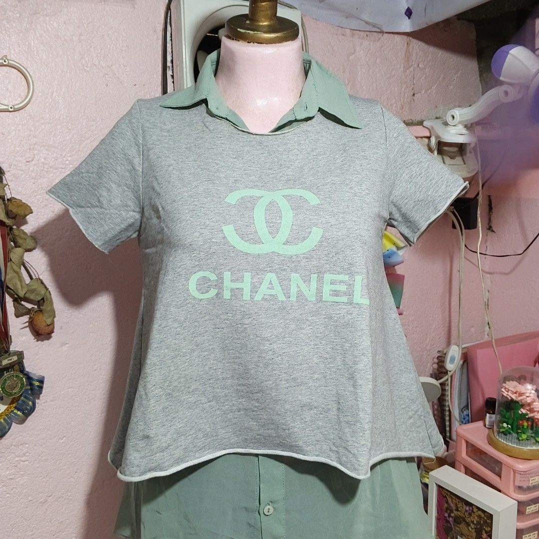 Grey T-shirt with Light Green Collar and Undershirt (Category: Shirts) located in Quezon City. Submitted by ysaai (Listing ID 1444688296, Image 1). Description: - Grey t-shirt with light green collar - Large Chanel logo and text on front - Layered look with light green undershirt detail - Short sleeves with raw hem finish - Ideal for casual and stylish wear ‎📍 Location: Quezon City ‎🧾 MOP: Gcash / Maya / GoTyme / Maribank ‎🛵 MOD: J&T / Lalamov
