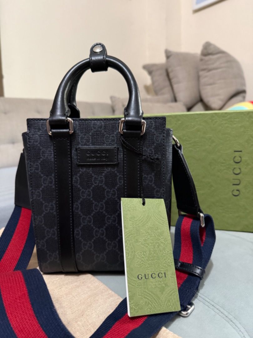 Gucci Ophidia GG Mini Tote Bag (Category: Luxury Bags & Wallets) located in Quezon City. Submitted by directrlmartinez (Listing ID 1444694178, Image 1). Description: - Authentic Gucci mini tote bag - Classic black GG monogram pattern - Top handles - Detachable strap with red and blue stripes - Made in Italy - Includes original dust bag and tags.