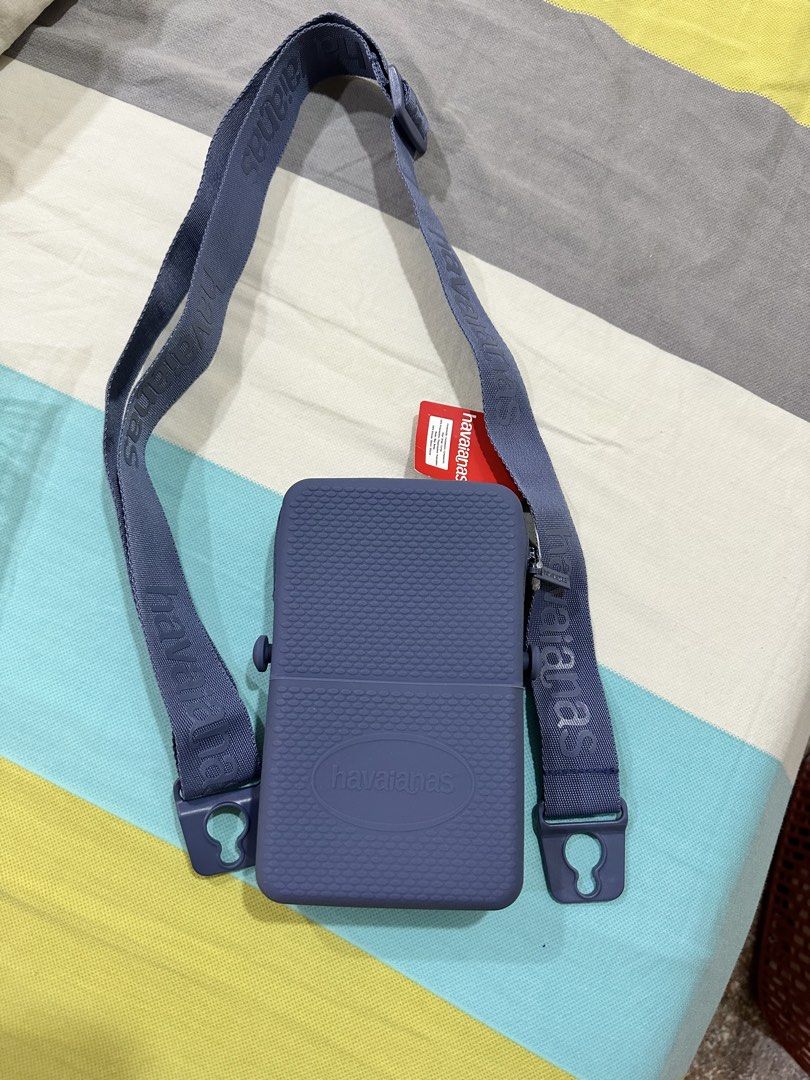 Havaianas Blue Crossbody Bag with Strap (Category: Cross-body Bags) located in Singapore. Submitted by bravedeer.721f80 (Listing ID 1444751450, Image 1). Description: - Blue Havaianas crossbody bag - Features prominent Havaianas logo on the front - Adjustable strap with printed Havaianas branding - Secure zipper closure - Ideal size for phone and small essentials - Perfect for on-the-go convenience.