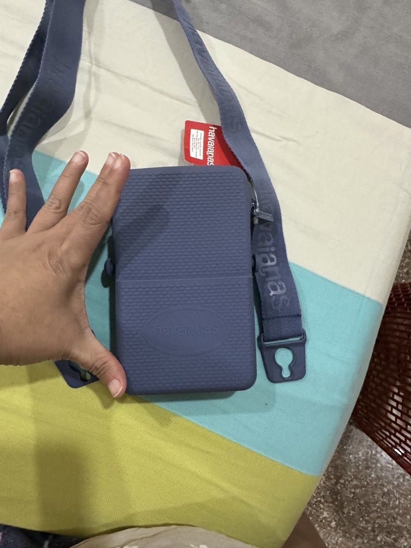 Havaianas Blue Crossbody Bag with Strap (Category: Cross-body Bags) located in Singapore. Submitted by bravedeer.721f80 (Listing ID 1444751450, Image 3). Description: - Blue Havaianas crossbody bag - Features prominent Havaianas logo on the front - Adjustable strap with printed Havaianas branding - Secure zipper closure - Ideal size for phone and small essentials - Perfect for on-the-go convenience.