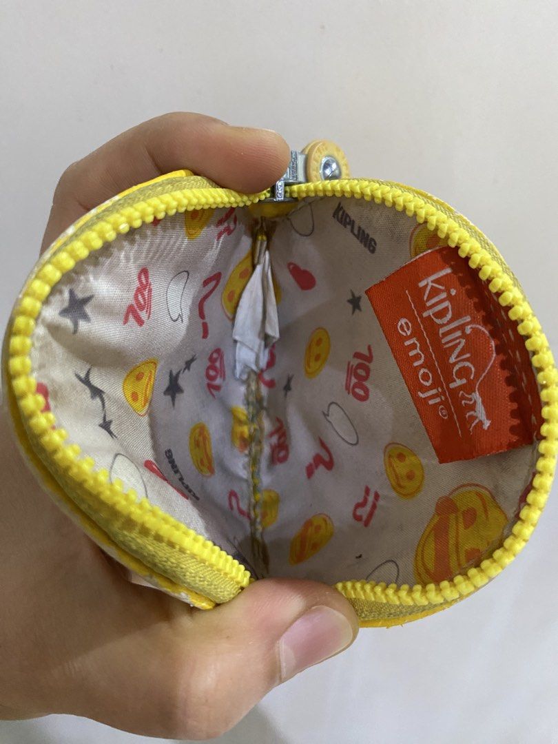 Kipling Emoji Yellow Coin Pouch with Chain (Category: Purses & Pouches) located in General Santos City (Dadiangas). Submitted by mylhing88 (Listing ID 1444794688, Image 3). Description: - Cute yellow Kipling coin pouch - Features 'emoji' design - Comes with a metal chain - Small and round shape - Ideal for coins or small essentials - Shows some signs of wear, still functional.