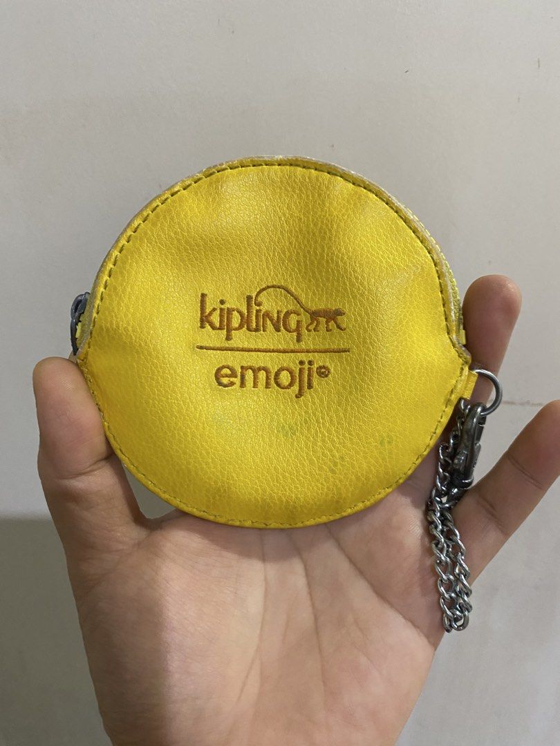 Kipling Emoji Yellow Coin Pouch with Chain (Category: Purses & Pouches) located in General Santos City (Dadiangas). Submitted by mylhing88 (Listing ID 1444794688, Image 1). Description: - Cute yellow Kipling coin pouch - Features 'emoji' design - Comes with a metal chain - Small and round shape - Ideal for coins or small essentials - Shows some signs of wear, still functional.