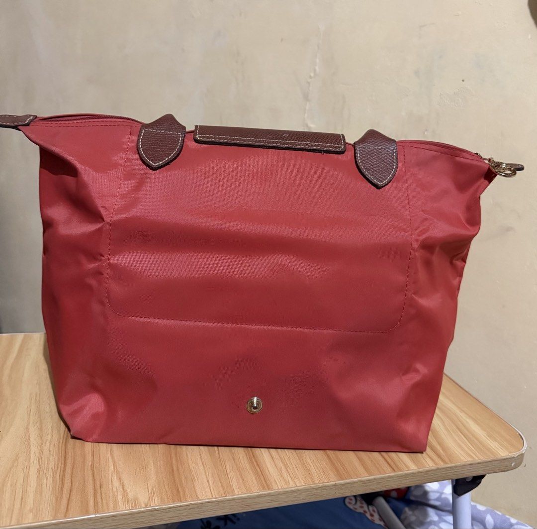 Longchamp Le Pliage Tote Bag - Tomato (Category: Luxury Bags & Wallets) located in Caloocan City. Submitted by chnnnnns (Listing ID 1444827706, Image 3). Description: - Classic Longchamp tote bag - Red nylon with brown leather handles and trim - Zips closed at the top - Ideal for everyday use - Spacious interior for essentials - Versatile and easy to carry.