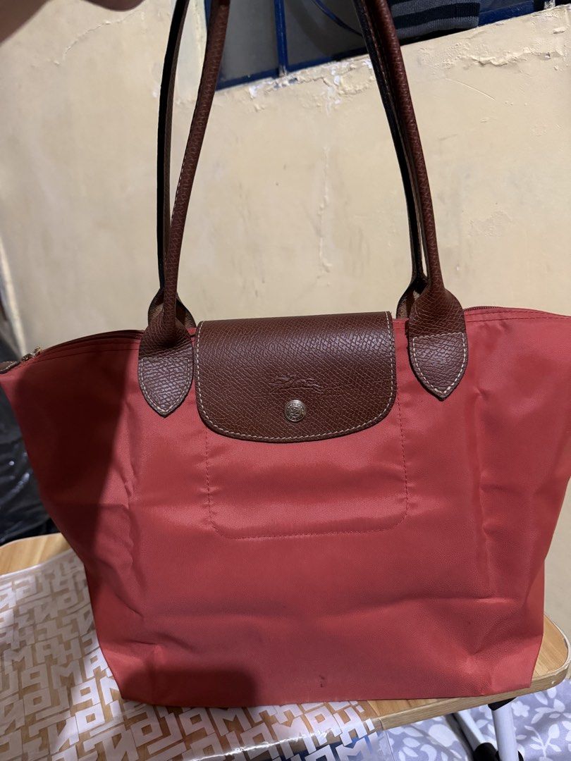 Longchamp Le Pliage Tote Bag - Tomato (Category: Luxury Bags & Wallets) located in Caloocan City. Submitted by chnnnnns (Listing ID 1444827706, Image 1). Description: - Classic Longchamp tote bag - Red nylon with brown leather handles and trim - Zips closed at the top - Ideal for everyday use - Spacious interior for essentials - Versatile and easy to carry.