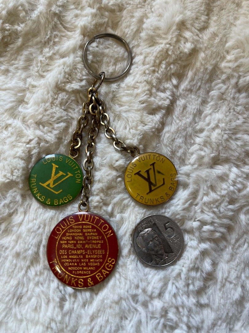Louis Vuitton Trunks & Bags Keychain with Charms (Category: Other Accessories) located in Naawan. Submitted by twilly.apparel2 (Listing ID 1444703032, Image 2). Description: -Louis Vuitton keychain - Features three charms: red (store locations), green, and yellow - All charms display the LV logo and 'Trunks & Bags' - Perfect accessory for your handbag or keys - Shows some signs of wear on the metal chains and charms.