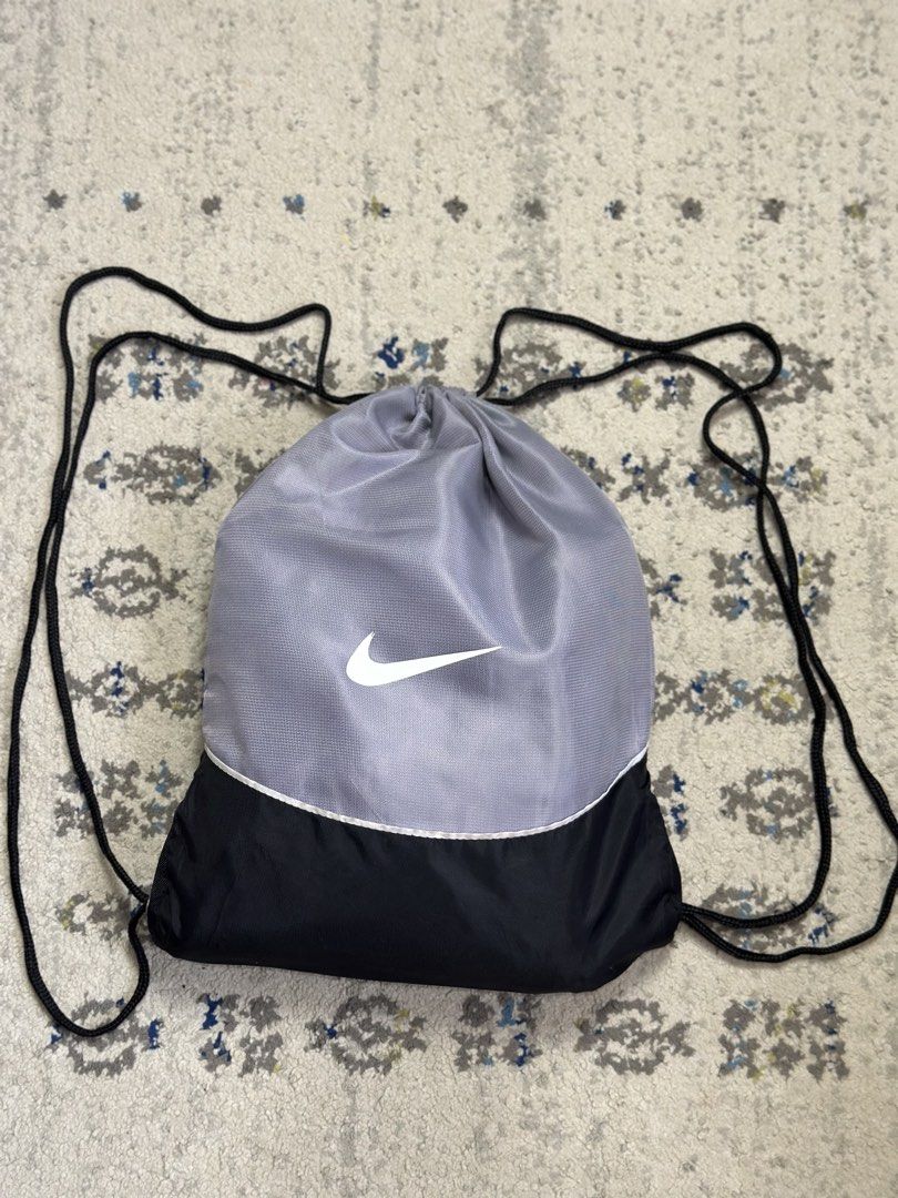Nike Drawstring Bag - Grey and Black (Category: Backpacks) located in Daet. Submitted by thrifthings2018 (Listing ID 1444754534, Image 1). Description: - Classic grey and black Nike drawstring bag - Features the iconic Nike swoosh logo - Simple, functional, and versatile design - Ideal for gym, sports, or everyday errands - Comfortable shoulder straps for easy carrying - Ample interior space for your essentials.