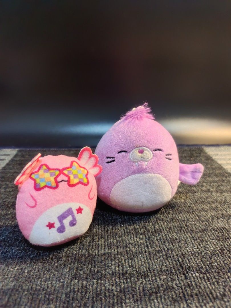 Original Squishmallows Archie Keychain Plush Toy (Category: Plushies & Soft Toys) located in Baguio. Submitted by 26_zerozero (Listing ID 1444837945, Image 1). Description: - Selling 2 original Squishmallows keychains. - Includes Archie (purple seal) and a pink owl. - Pink owl features star sunglasses and musical notes. - Both keychains have clips attached. - Perfect for decorating bags, backpacks, or purses. - Super soft and squishy texture..