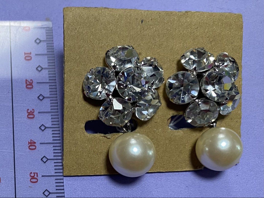 Pearl Drop Earrings with Crystal Flower Design (Category: Earrings) located in Mabalacat. Submitted by somethingoldsomethingnew28 (Listing ID 1444740388, Image 1). Description: - Sparkly crystal flower design - Features a single creamy white pearl drop - Clip-on style, no piercing needed - Clear crystals catch the light beautifully - Ideal for dressing up any outfit - Sold as a pair.