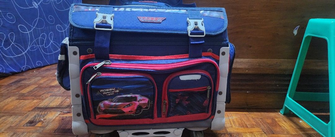 Robby Rabbit Extreme Drive Large Trolley School Bag (Category: Backpacks) located in Manila. Submitted by maybelle00 (Listing ID 1444681628, Image 2). Description: - Large Robby Rabbit trolley school bag - Color: Navy blue with red and blue accents - Design: Features a cool car graphic on the front - Easy Transport: Equipped with wheels and a retractable handle - Organization: Multiple compartments for school supplies - Ideal for: Students who ne