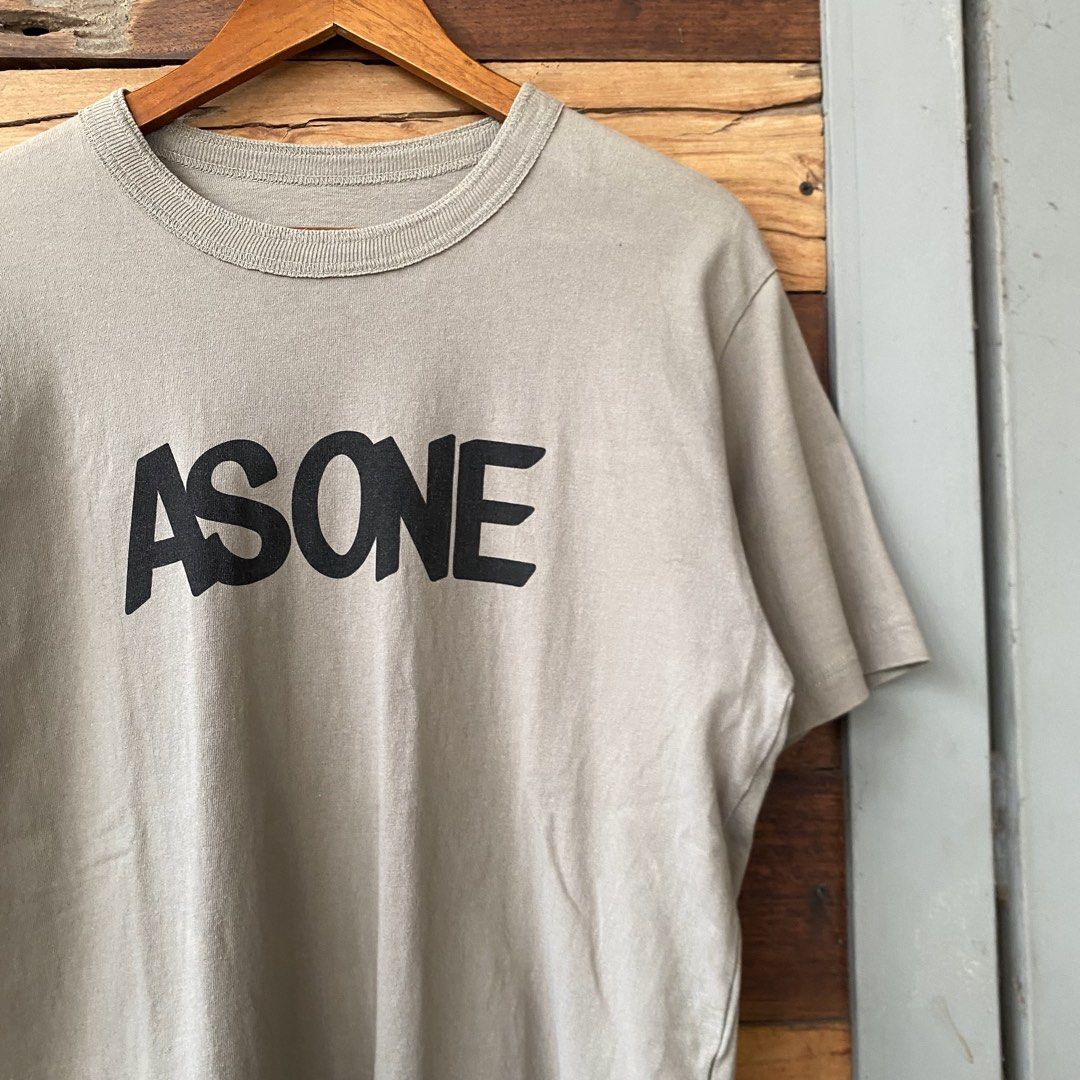 Sacai AS ONE T-shirt (Category: Tshirts & Polo Shirts ) located in Los Banos. Submitted by rick_06 (Listing ID 1444820500, Image 2). Description: - Sacai t-shirt with 'AS ONE' graphic print on front. - Small Sacai logo detail on the back near the collar. - Tag indicates 100% cotton material. - Ideal for everyday casual wear..
