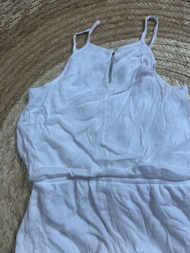 White Crinkle Romper with Drawstring Waist (Category: Babies & Kids Fashion) located in Tarlac. Submitted by relovedph_02 (Listing ID 1444745327, Image 3). Description: - White crinkle fabric romper - Adjustable spaghetti straps - Keyhole neckline - Elasticated waist with drawstring tie - Ruffled hem shorts - Small dark mark on front (see second photo) - Ideal for casual wear or beach outings.