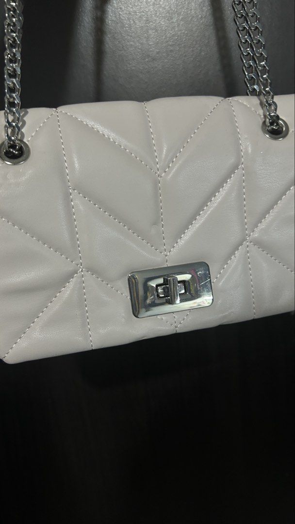 White Quilted Chain Bag with Silver Clasp (Category: Luxury Bags & Wallets) located in Manila. Submitted by kyvsphy (Listing ID 1444756454, Image 2). Description: - White quilted handbag with elegant chevron pattern - Secure silver turn-lock closure - Stylish silver chain strap - Versatile for nights out or casual wear.