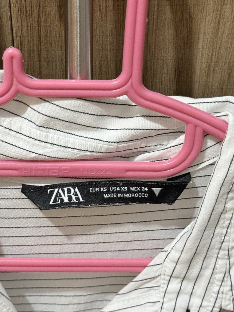 ZARA Striped Long Sleeve Shirt (Category: Longsleeves) located in Quezon City. Submitted by Cells_Collection (Listing ID 1444788075, Image 2). Description: - Classic white shirt with thin black pinstripes - Button-up front with a collar - Long sleeves with button cuffs - Relaxed fit for comfort - Versatile for casual or work outfits - Effortless to style.