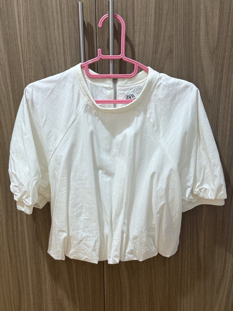 Zara White Puff Sleeve Cropped Top (Category: Blouses) located in Quezon City. Submitted by Cells_Collection (Listing ID 1444787926, Image 1). Description: - White Zara cropped top - Features stylish puff sleeves - Gathered hem for a flattering fit - Convenient back zipper closure - Size: Small (S) - Made in Turkey - Versatile for casual or dressed-up looks.