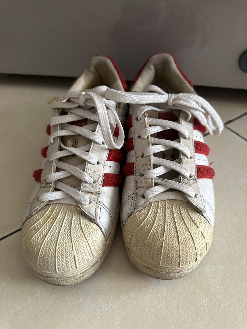 Adidas Superstar White Red Sneakers (Category: Sneakers) located in Mandaluyong City. Submitted by miaaaa32 (Listing ID 1441420602, Image 3). Description: - Classic Adidas Superstar sneakers - White leather with iconic red stripes - Unique fuzzy trim detail (limited edition) - Signature shell toe design - Perfect for everyday casual style -Has signs of use but no issues (slipping, cracks) - Sold as is Open to nego Return and refund only if produc