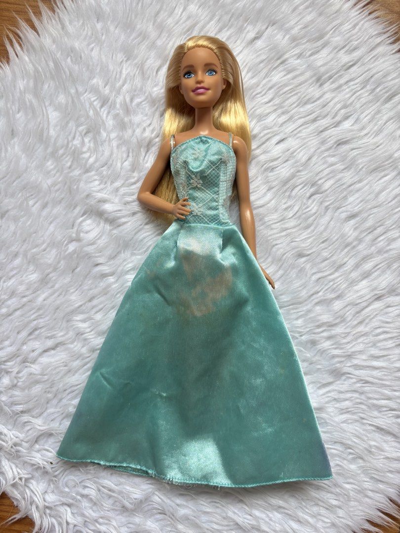 Barbie Doll Preloved (Category: Kids Toys) located in Bulacan. Submitted by lmsdeclutteringcorner (Listing ID 1441422553, Image 1). Description: - Blonde Barbie doll - Teal satin gown with lace bodice detail - Light staining on the front of the skirt - Long blonde hair - Articulated doll body.