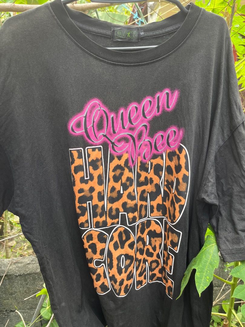 Black Queen Bee Hard Core T-shirt (Category: Tshirts & Polo Shirts ) located in Calapan. Submitted by thrifts_trap10210729 (Listing ID 1441535892, Image 1). Description: - Black t-shirt with 'Queen Bee Hard Core' graphic print - Features a leopard print design within the text - Crew neck, short sleeves - Ideal for casual wear.