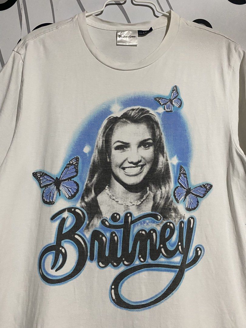 Britney Spears Shirt (Category: Shirts) located in Cebu City. Submitted by patspickph (Listing ID 1441530470, Image 2). Description: This white Britney Spears vintage-style t-shirt features a blue airbrushed graphic of the singer surrounded by blue butterflies. W20.5 L28.5 Excellent Condition.