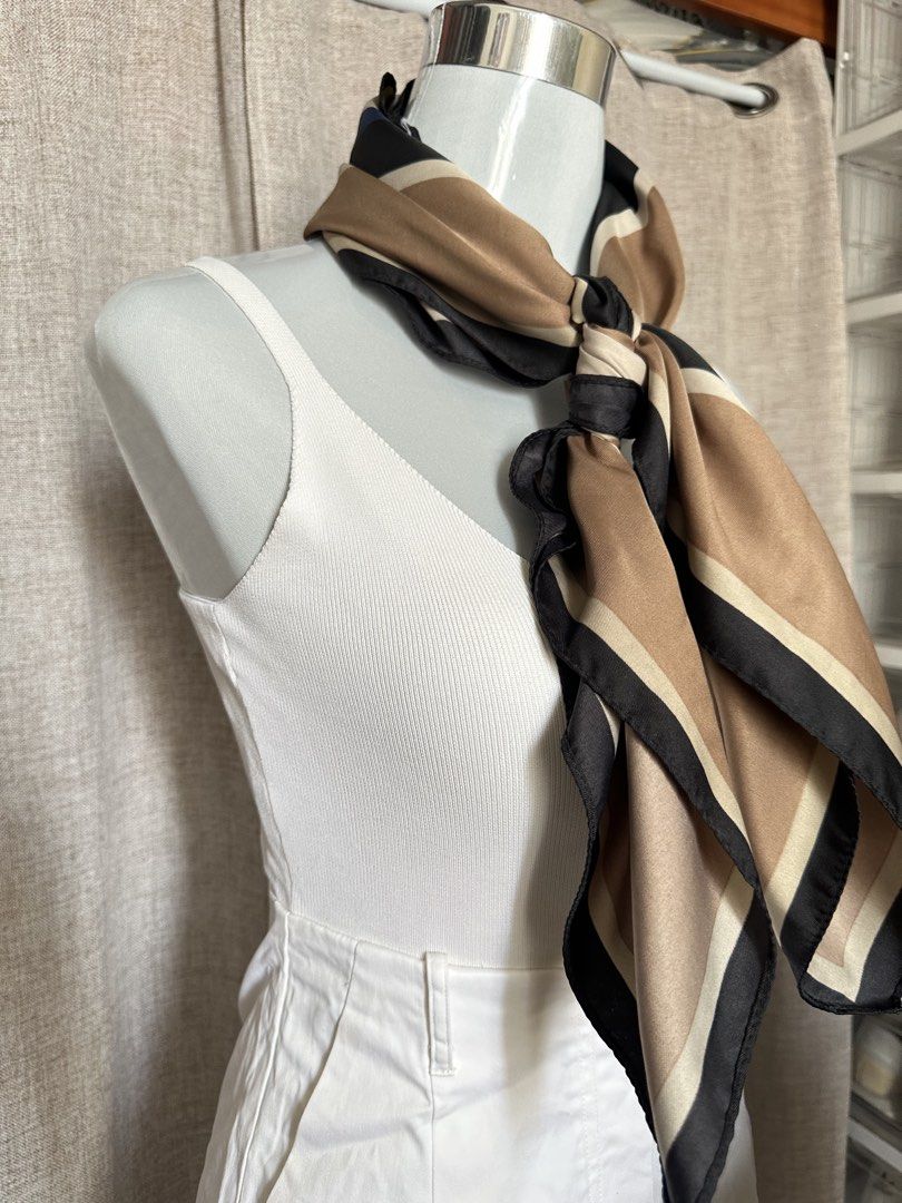 Brown and Black Striped Silk Scarf (Category: Scarves) located in Manila. Submitted by alaisashainne (Listing ID 1441578869, Image 3). Description: - Beautiful silk scarf - Classic brown, black, and beige stripe pattern - Approximately 25x25 inches - Versatile styling: wear on neck, bag, or as hair accessory - Adds color and sophistication to any outfit - Perfect for dressing up simple looks.