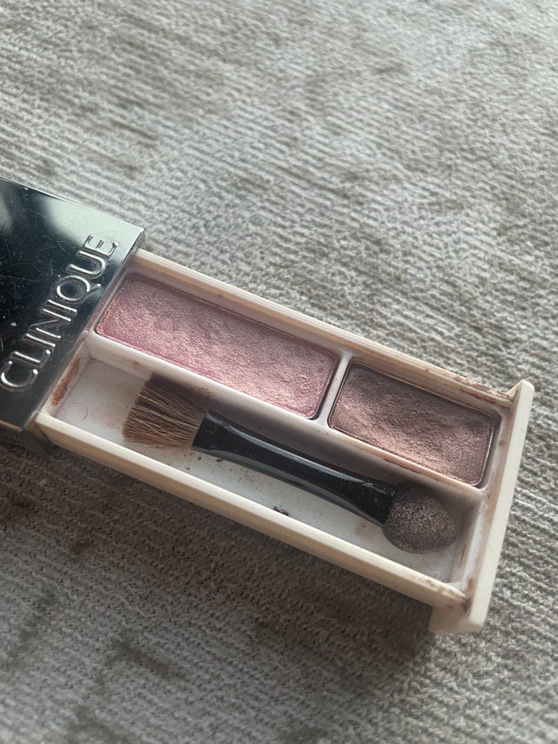 Clinique Eyeshadow Duo Palette (Category: Makeup) located in Makati City. Submitted by candicedayo (Listing ID 1441487873, Image 2). Description: - Clinique eyeshadow palette - Two shimmery shades: light pink and bronze - Includes applicator brush - Minor powder residue inside - Case has minor scuffs - Ideal for quick touch-ups.