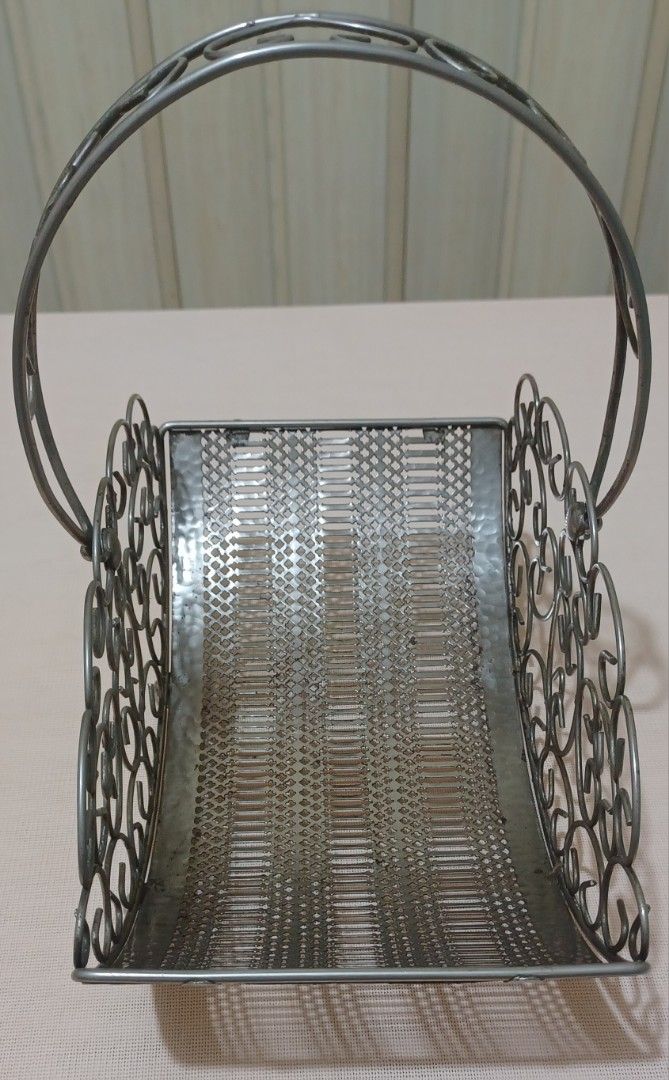 Decorative Metal Wire Basket with Handle (Category: Storage Boxes & Baskets) located in Quezon City. Submitted by wjmae (Listing ID 1441427182, Image 3). Description: - Decorative metal wire basket - Features an ornate handle - Intricate scrollwork along the sides - Woven pattern on the base - Stands on small ball feet - Ideal for holding fruit, flowers, or general organization - Adds a vintage aesthetic to any room.