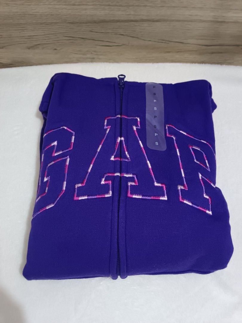 GAP Purple Zip-Up Hoodie (Category: Hoodies) located in Quezon City. Submitted by shinereign (Listing ID 1441439299, Image 1). Description: - Purple zip-up hoodie from GAP - Features classic GAP logo with pink and white checkered fill across the chest - Drawstring hood for adjustable comfort - Convenient front pockets - Ideal for everyday casual wear.