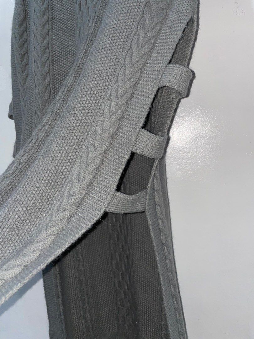 Grey Cable Knit Sleeveless Long Sweater Vest (Category: Sleeveless) located in Baguio. Submitted by everafterbgo (Listing ID 1441548643, Image 2). Description: - Long grey cable knit sweater vest - Sleeveless design - Unique strap details on the sides - Ideal for layering over tops or dresses - Cozy and stylish for cooler weather.